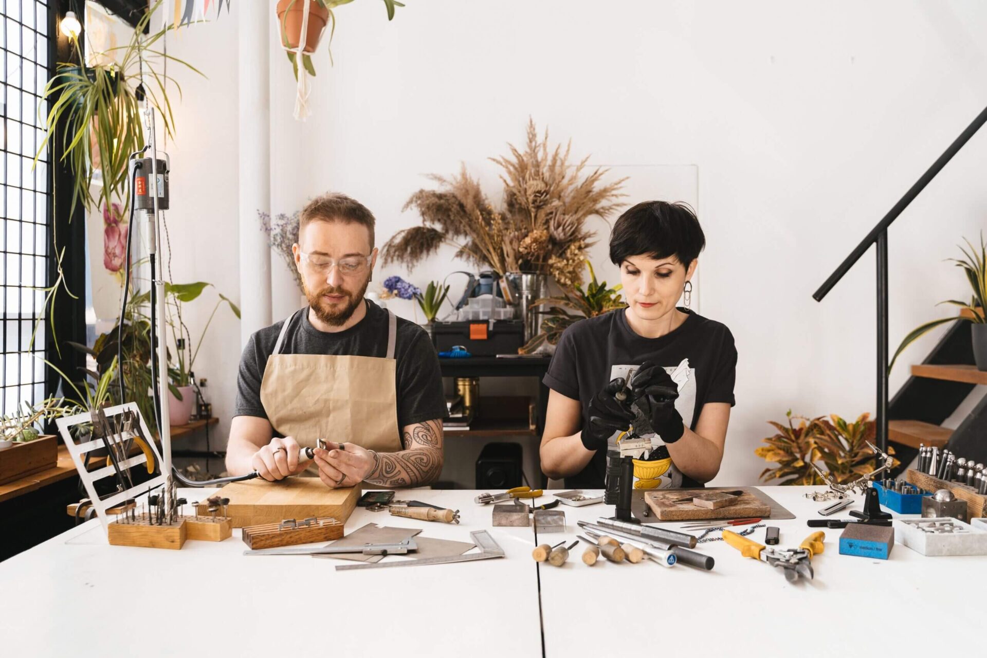 a man and a womnan doing arts and crafts on a desk
