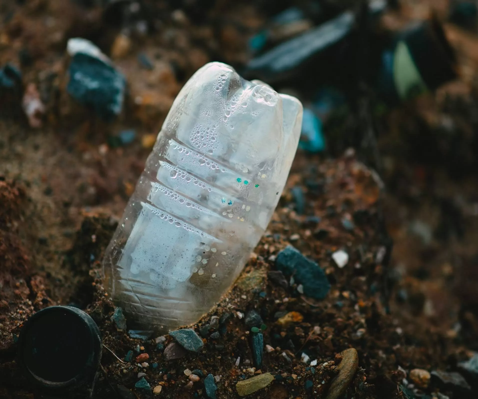 white plastic bottle on brown soil