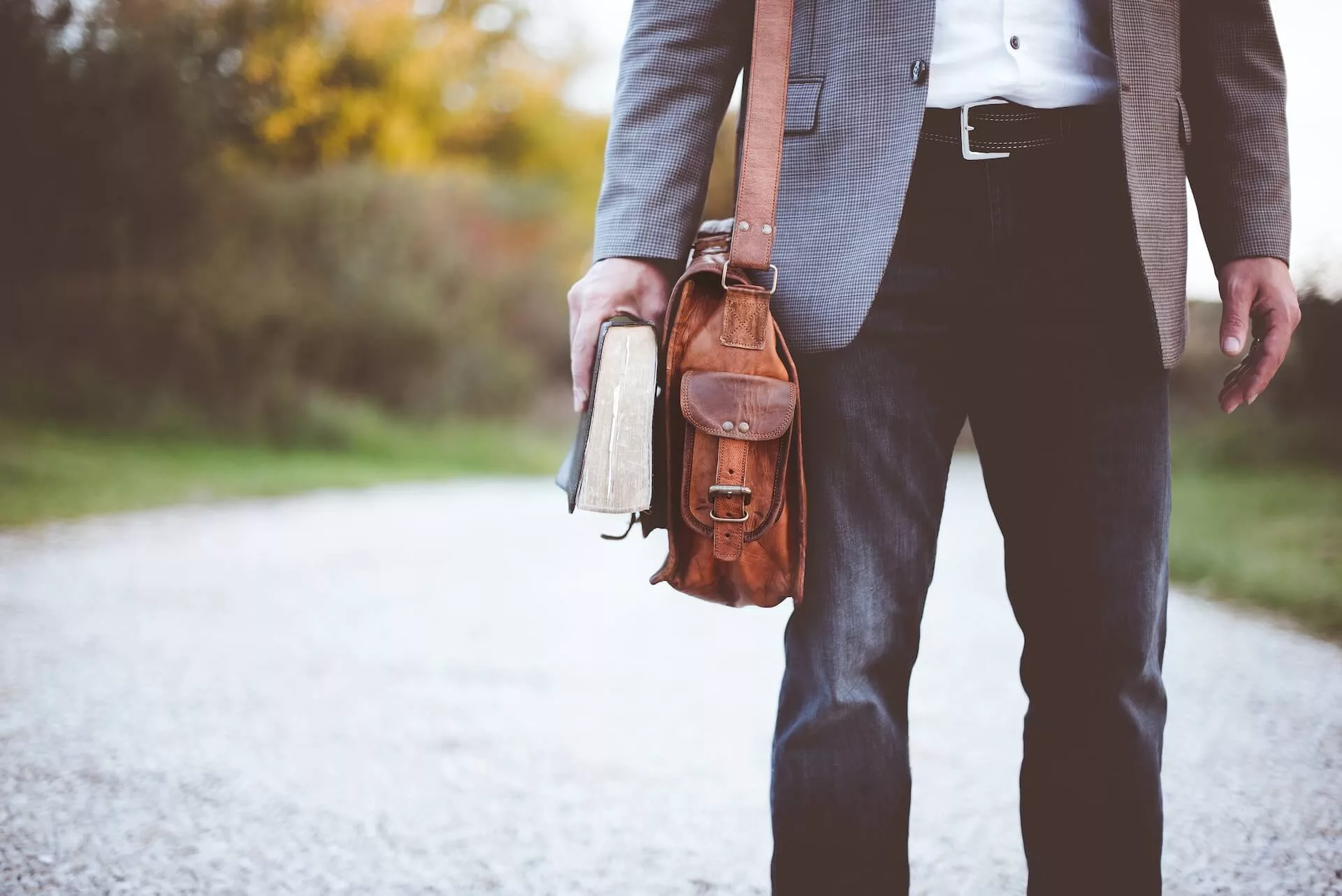 Man with leather bag and book